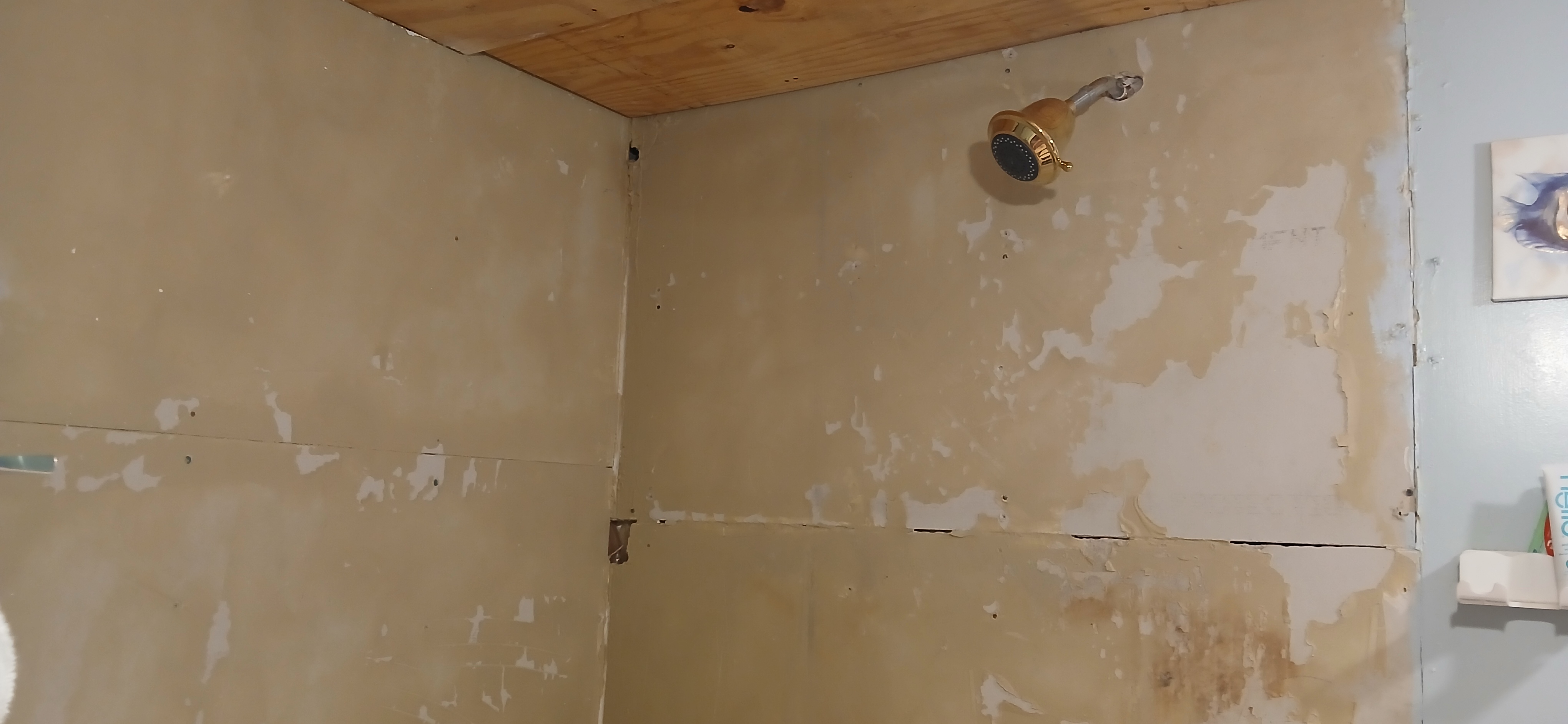 Unfinished shower remodel with bare drywall before tiling in mobile home bathroom